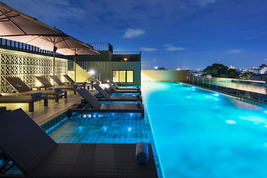 Illuminated rooftop pool overlooking Bangkok at night